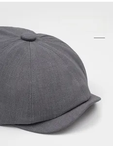 Detailed top view of dark grey newsboy hat showing fabric texture and crown button