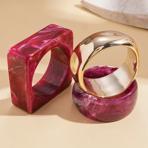 Three-piece ring set with burgundy resin marble pattern and wide gold metallic bands