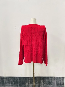 Detail of red cable knit sweater back showing intricate knitted patterns and texture