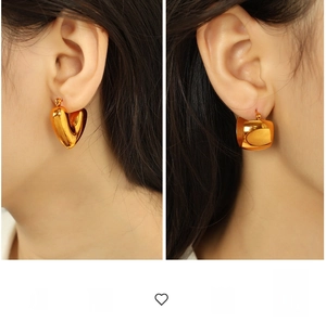Boucles d'oreilles créoles dorées en forme de cœur et larges sur un mannequin