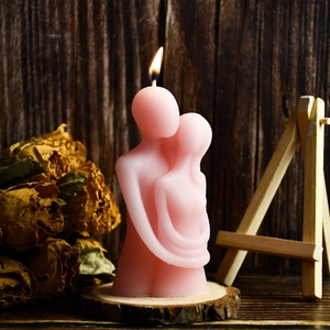 Detailed view of pink embrace couple candle with matte texture on wooden base