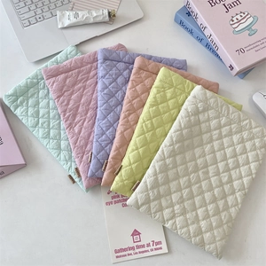 Close-up of quilted diamond pattern laptop sleeves in multiple pastel colors