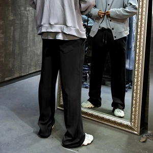 Detailed view of black vertical striped knit texture on loose wide-leg men trousers