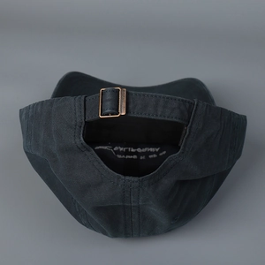 Detail view of washed cotton baseball cap with adjustable metal buckle and embroidery
