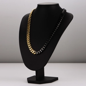 Two-tone gold and black stainless steel Cuban link necklace for men on a bust display