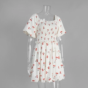Close-up of square neck dress featuring cherry print and elastic smocked chest detail