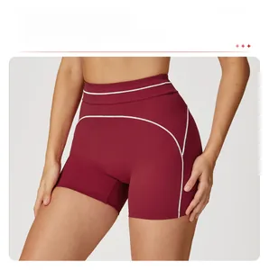 Macro detail of high-waist yoga shorts in burgundy with white contrast stitching