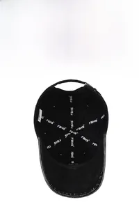 Detail of washed cotton baseball cap interior featuring breathable eyelets and logo tape