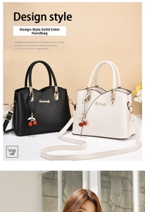 Detail view of wavy handbags with gold branding and delicate cherry charms in two colors