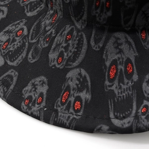 Macro detail of black cowboy hat fabric with skull pattern and sparkling red glitter eyes