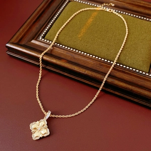 Détail du pendentif fleur en losange doré avec zircons sur une chaîne torsadée