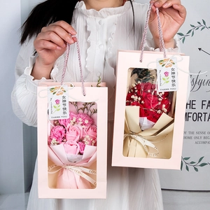 Model holding a soap flower gift box with roses and carnations in a pink tote bag