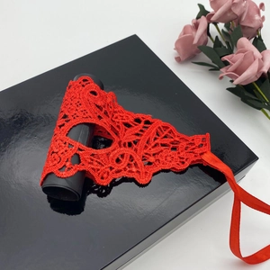 Elegant red lace masquerade mask on a black gift box with delicate floral accent