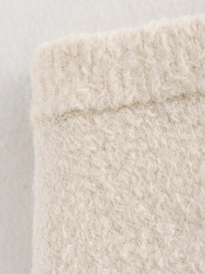 Close-up of beige knit fabric texture and premium stitching details for chic women sets