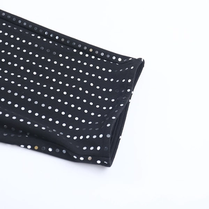 Gros plan détaillé montrant l'imprimé à pois blancs sur le tissu extensible noir