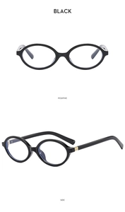 Detail of black oval anti-blue light glasses frame with golden metal hinge accents