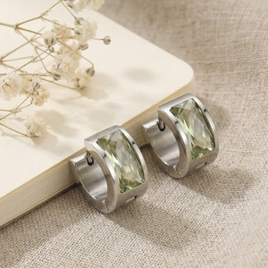 Detail of silver stainless steel hoop earrings with rectangular pale green gemstones