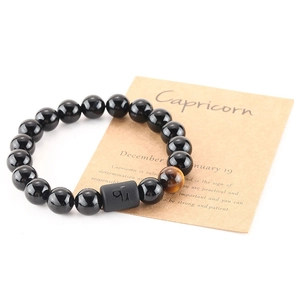 Detail of 8mm black beads stretch bracelet with tiger eye stone and Capricorn symbol