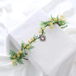 Fairy flower crown headband with yellow blossoms, green leaves and pink crystal pendant