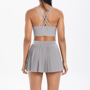 Detail of light grey sports bra with criss-cross back and pleated tennis skirt set
