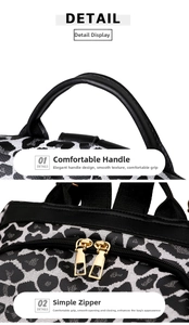 Detail view of rounded faux leather handle and smooth golden double zippers on leopard print bag