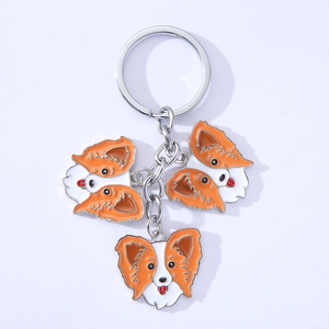 Detail of dog keychain featuring orange and white enamel Papillon pendants on metal ring