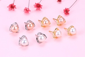 Macro shot of triangle S925 silver earrings with white and pink freshwater pearls