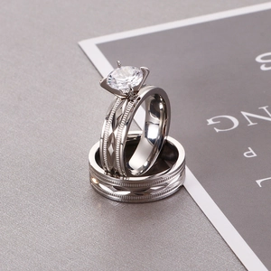 Close-up of stacked silver wedding ring set with six-prong diamond and textured band