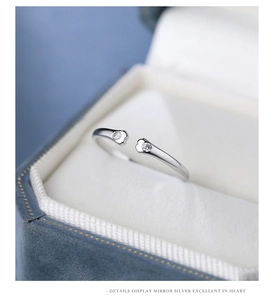 Detail of silver cat paw ring with sparkling zircon in a blue velvet jewelry box