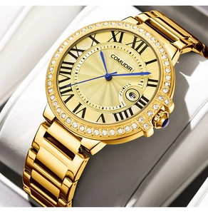 Macro shot of gold stainless steel watch dial with Roman numerals and blue gemstone crown