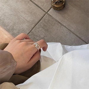 Close-up of minimalist 925 silver bow knot ring worn on index finger with sleek finish