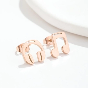 Music themed rose gold asymmetrical stud earrings featuring headphone and note designs