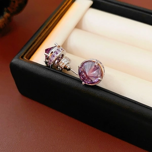Close-up of 18k gold plated silver earrings with large purple stones in a black box