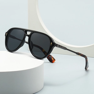 Classic pilot sunglasses with black square frames and tortoise shell temples on a white base