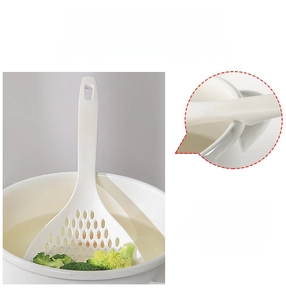 Close-up of a white slotted spoon with a non-slip support handle resting on a cooking pot