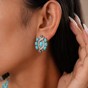 Gros plan de boucles d'oreilles vintage bohème avec résine turquoise et strass brillants