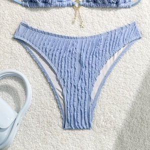 Detail of light blue bikini bottom with ribbed texture and pearl starfish charm