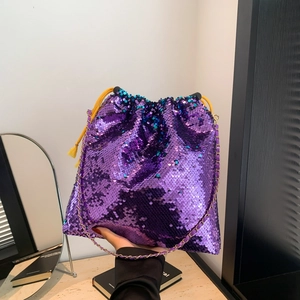 Detailed shot of purple sequin bucket bag with yellow drawstring and gold chain strap