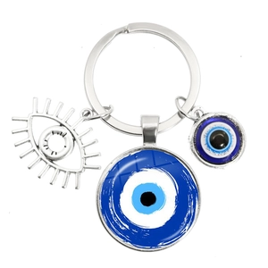 Blue evil eye keychain with silver eyelash pendant and glass gemstone charms on white background
