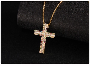 Close-up of gold-plated cross pendant with micro-pave zircons and colorful gemstones