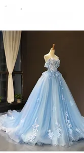 Detailed close-up of light blue off-shoulder gown with floral lace and layered mesh