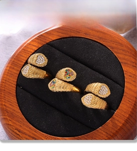 Detailed view of PVD gold plated snake rings with heart-shaped zircon inlays on black velvet
