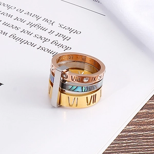 Detailed view of stacked Roman numeral rings with shell inlay and zircon accents