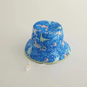 Detail of blue kids sun hat with cartoon dinosaur prints and adjustable chin strap