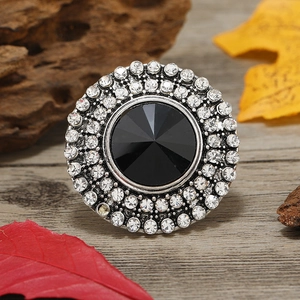 Macro shot of circular vintage ring with black faceted gemstone and crystal pavé details