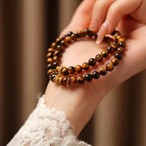 Double-layered tiger eye bead bracelet with golden accents on a model's wrist