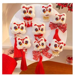 Close-up of Chinese New Year lion dance hair clips with fluffy pompons and red tassels