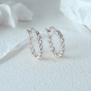 Macro shot of minimalist S925 sterling silver chain hoop earrings with twisted design
