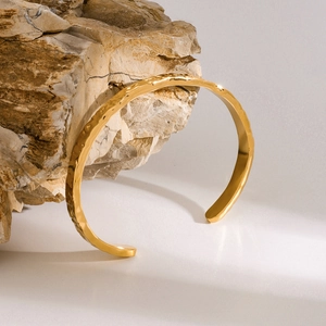 18k gold plated stainless steel open bangle with unique hammered texture on natural stone