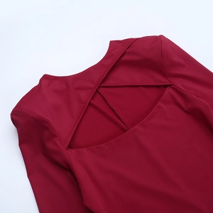 Detalle de vestido rojo oscuro con elegante espalda cruzada y diseño de cortes huecos